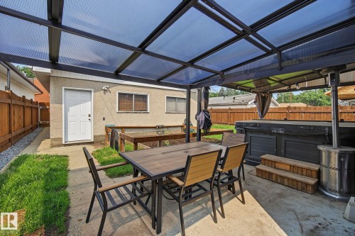 Covered patio space featuring a translucent roof, concrete flooring, and a privacy fence - 3622 115 Avenue, Edmonton, AB 