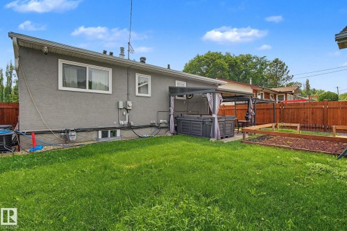 Expansive backyard featuring a lush lawn, privacy fencing, and a dedicated patio area - 3622 115 Avenue, Edmonton, AB 
