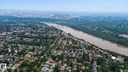 Aerial perspective showcasing a residential area bordered by a prominent river and extensive green spaces - 3622 115 Avenue, Edmonton, AB 