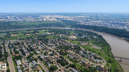 Aerial perspective showcasing a residential neighborhood with a winding river and lush green spaces - 3622 115 Avenue, Edmonton, AB 