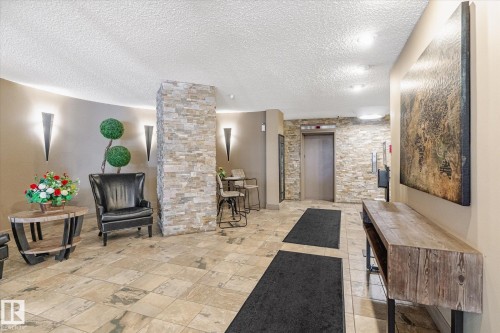 Lobby area featuring tiled flooring and a prominent stone-clad pillar - 503 10045 117 Street, Edmonton, AB 