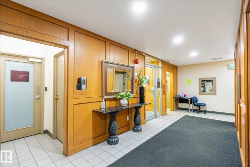 Hallway featuring paneling, tile flooring, recessed lighting, and multiple entryways - 503 10045 117 Street, Edmonton, AB 