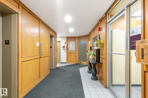Corridor featuring wood paneling, recessed lighting, and elevator access - 503 10045 117 Street, Edmonton, AB 