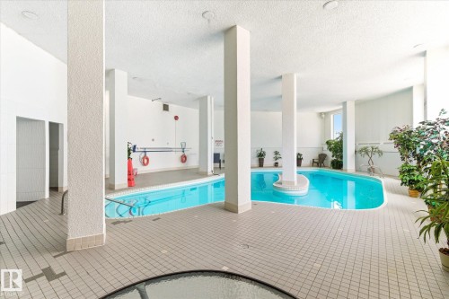 Indoor swimming pool with light blue water and surrounding tiled deck - 503 10045 117 Street, Edmonton, AB 