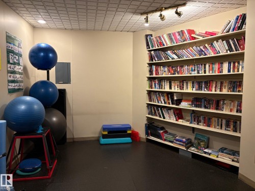 Built-in shelving unit with extensive storage, textured ceiling, track lighting fixture, and durable flooring - 503 10045 117 Street, Edmonton, AB 