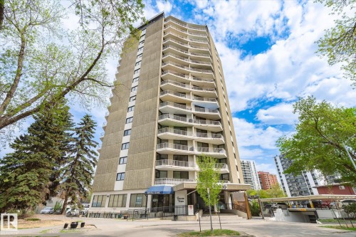 Concrete high-rise building featuring multiple balconies, ground-level commercial/retail space, and a covered entrance - 503 10045 117 Street, Edmonton, AB 