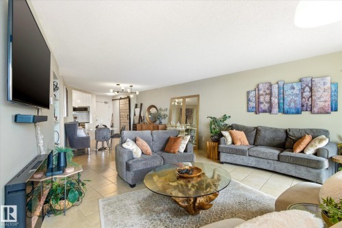 Spacious living area featuring neutral wall tones and tile flooring - 503 10045 117 Street, Edmonton, AB 