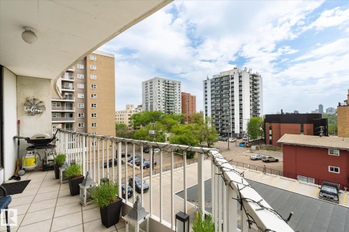 Expansive outdoor balcony featuring a tiled floor and a white metal railing - 503 10045 117 Street, Edmonton, AB 