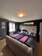 Spacious room featuring wood-finish flooring, a window with dark curtain rods, and dark wall paint - 