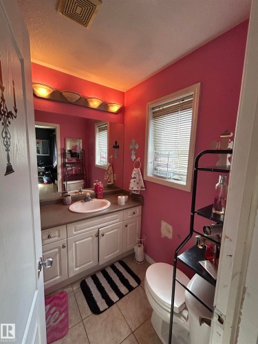 Bathroom featuring a single vanity with white cabinetry, an integrated sink, and a laminate countertop - 17 Willowby Close, Stony Plain, AB 