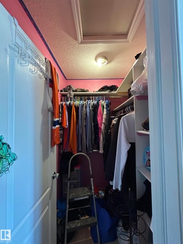 Walk-in closet featuring built-in shelving, clothing rods, and overhead lighting - 17 Willowby Close, Stony Plain, AB 