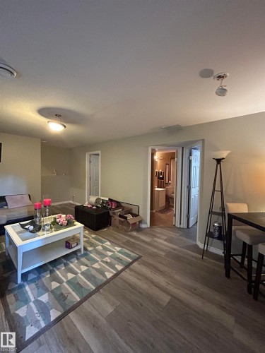 Open-concept living space featuring wood-finish flooring, neutral wall tones, and recessed lighting - 17 Willowby Close, Stony Plain, AB 