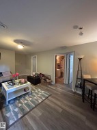 Open-concept living space featuring wood-finish flooring, neutral wall tones, and recessed lighting - 