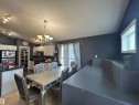Open-concept kitchen and dining area featuring white cabinetry, dark countertops, a vaulted ceiling, wood-finish flooring, and track lighting - 17 Willowby Close, Stony Plain, AB 