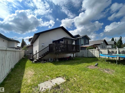 Backyard featuring a wooden deck with a staircase, vinyl siding, and a partial wooden privacy fence - 17 Willowby Close, Stony Plain, AB 