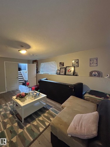 Recreational room featuring wood-finish flooring, light-colored walls, and a ceiling-mounted light fixture - 17 Willowby Close, Stony Plain, AB 