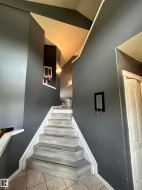 Staircase with wood-finish treads and white risers, complemented by a tiled floor landing - 