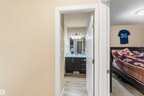 Bathroom vanity with a dark wood-finish cabinet, a white countertop, and a chrome faucet - 17118 108 Street, Edmonton, AB 