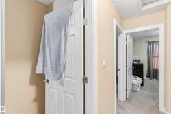 Interior hallway featuring neutral wall paint and a textured ceiling - 