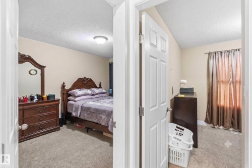 Carpeted bedroom featuring neutral wall tones and a ceiling-mounted light fixture - 17118 108 Street, Edmonton, AB 