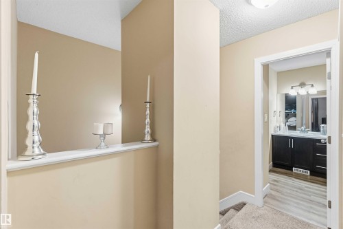 Bathroom featuring a dark wood-finish vanity with a single basin sink, wall-mounted mirror, and three-bulb vanity lighting - 17118 108 Street, Edmonton, AB 
