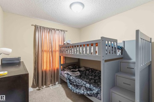 Carpeted room with neutral wall paint and a textured ceiling - 17118 108 Street, Edmonton, AB 
