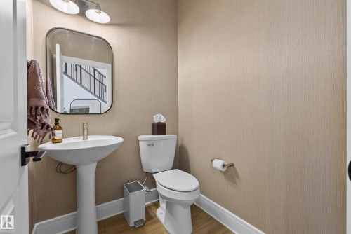 Pedestal sink with a contemporary rectangular mirror, accented by a wall-mounted light fixture - 20907 131 Avenue, Edmonton, AB 