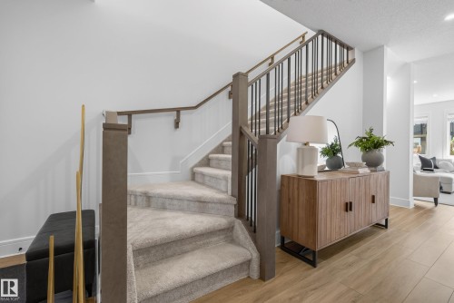 Carpeted staircase with dark wood newel posts and handrails, complemented by black iron balusters - 20907 131 Avenue, Edmonton, AB 
