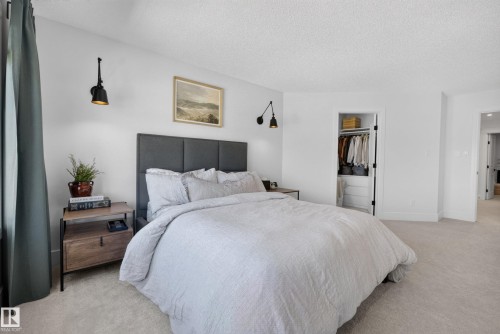 Spacious room featuring light-colored carpeting, a built-in closet with shelving, and wall-mounted sconce lighting - 20907 131 Avenue, Edmonton, AB 