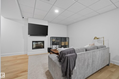 Living area featuring a built-in fireplace, recessed lighting, and a drop ceiling - 20907 131 Avenue, Edmonton, AB 