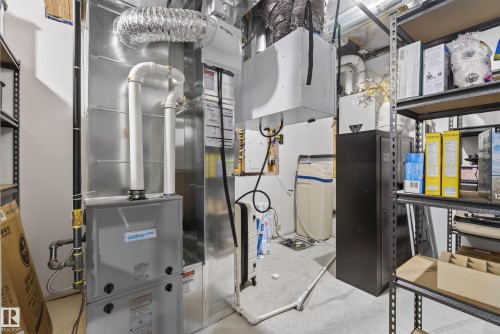 Utility room featuring a furnace, water softener system, and built-in metal shelving - 20907 131 Avenue, Edmonton, AB 