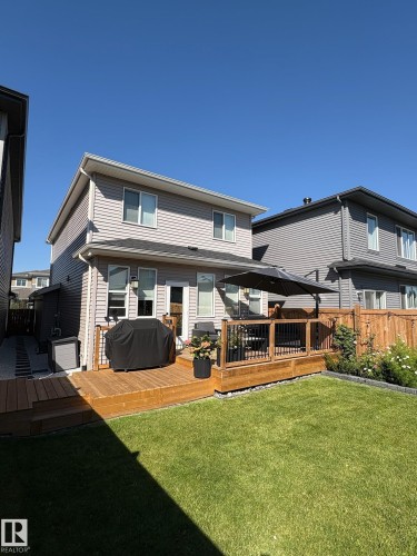 Spacious wooden multi-level deck featuring a black railing system and direct access to the interior - 20907 131 Avenue, Edmonton, AB 