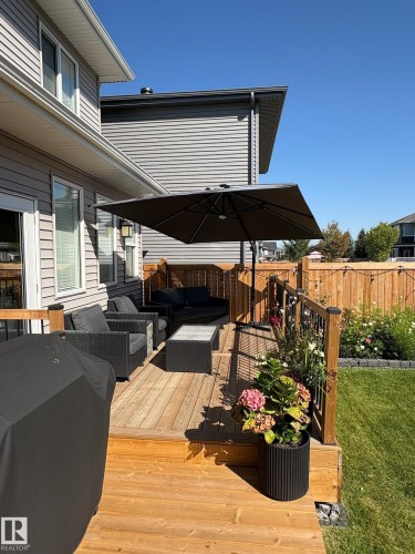 Multi-level wood deck featuring a railing system and steps to the lawn - 20907 131 Avenue, Edmonton, AB 