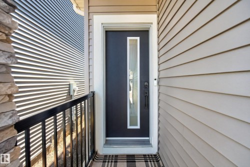 Entry door featuring a vertical glass insert and a matte black handle set - 20907 131 Avenue, Edmonton, AB 