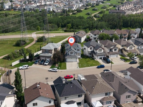 Two-story residence with a light gray exterior and white trim, featuring a concrete driveway and an attached garage - 3449 28 Street, Edmonton, AB 