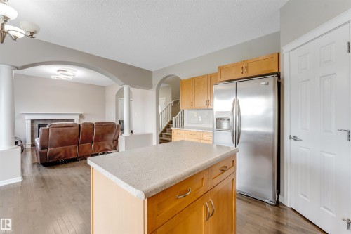 Kitchen island with light-toned countertop and wood-finish cabinetry - 3449 28 Street, Edmonton, AB 