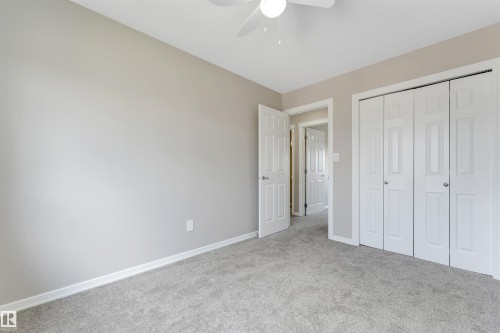 Carpeted interior room featuring light gray walls, white baseboards, and a ceiling fan - 3449 28 Street, Edmonton, AB 