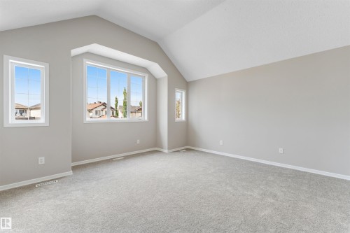 Spacious interior featuring a vaulted ceiling and light gray carpeting - 3449 28 Street, Edmonton, AB 