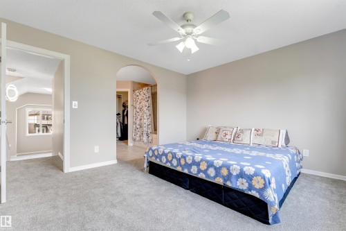 Bedroom featuring light gray wall paint, gray carpet flooring, and a ceiling fan with integrated lighting - 3449 28 Street, Edmonton, AB 