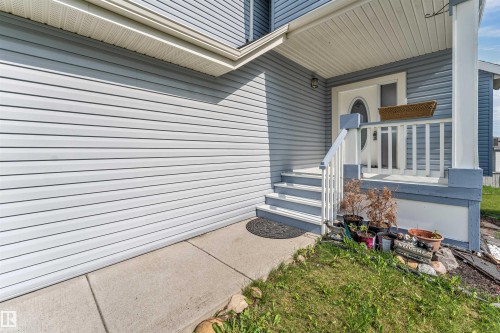 Front entrance featuring a white oval-lite door and a covered porch - 3449 28 Street, Edmonton, AB 