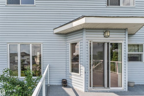 Light-colored horizontal siding exterior featuring a covered deck area - 3449 28 Street, Edmonton, AB 