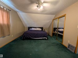 Room featuring sloped ceilings, wall-to-wall carpeting, and a ceiling fan with integrated lighting. - 