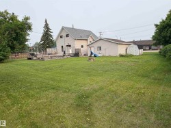 Expansive lawn with  residence, a detached garage, and a shed. - 
