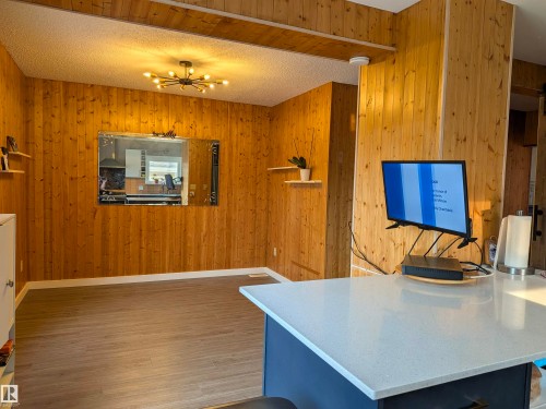Wood-paneled accent wall with integrated shelving and a decorative wall mirror. - 4806 50 Avenue, Elk Point, AB 