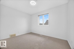 Neutral-toned carpeting paired with white walls, baseboards, and trim - 