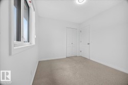 Neutral wall paint with baseboard trim, window with white casing, light-colored carpeting, and a flush-mount ceiling light fixture - 
