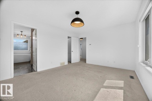 Spacious room with light-toned carpeting and bright white walls - 8508 218 Street, Edmonton, AB 