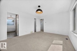 Spacious room with light-toned carpeting and bright white walls - 