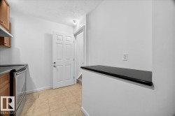 Functional kitchen area featuring warm-toned cabinetry, a built-in stainless steel range, and a breakfast bar with a dark countertop - 