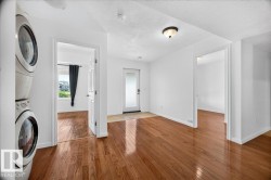 Bright entryway featuring wood-finish flooring, white walls, and a recessed ceiling light fixture - 